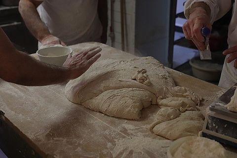 Photo des mains de 3 boulangers travaillant la pâte
