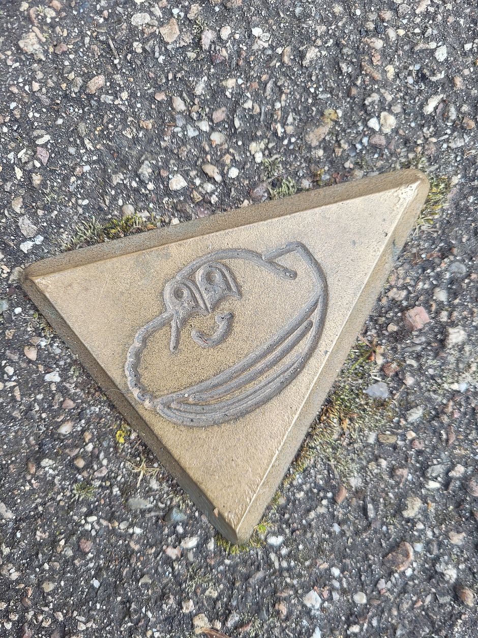 Plaque en métal dessin de madeleine pour marquer le chemin du circuit de la Cité Médiévale