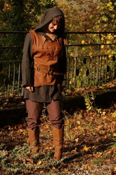 Tenue médiévale de type Robin des Bois confectionnée par l'atelier boutique Amarrage portée par une femme devant la rembarde du parc du Château Corbin - Agrandir l'image, .JPG 67 Ko (fenêtre modale)